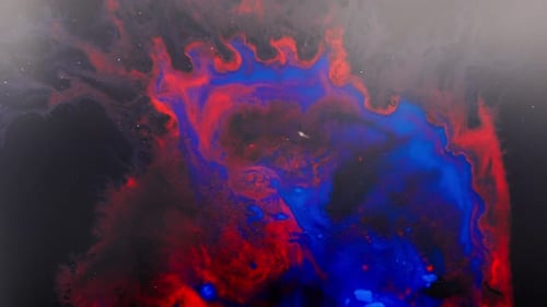 Abstract shot of alcohol ink in vivid red and blue blending into cosmic shapes
