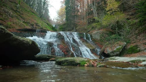 Mountain stream cascading over rocks in autumn forest