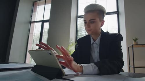 Young Adult on Tablet in Bright Modern Office