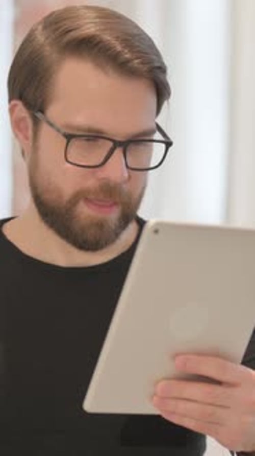 Man Using Tablet Reacts to Good News