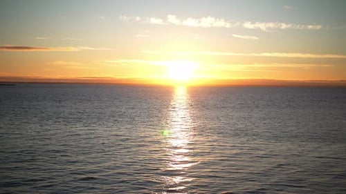 Beautiful Colorful Beach Sunset or Sunrise at Sea with Clouds and with Reflection Sun Rays in Water