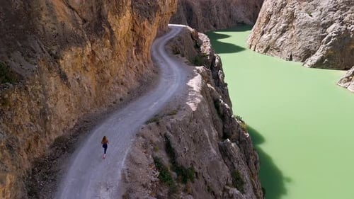 Woman Runs Edge Mountain Trail Near River