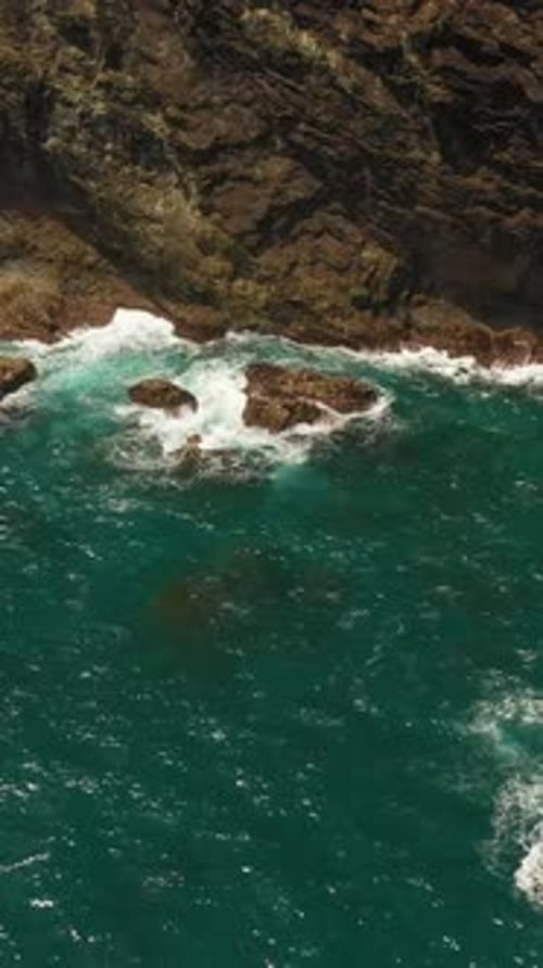 Dramatic Ocean Waves Crashing Against Rocky Cliffside