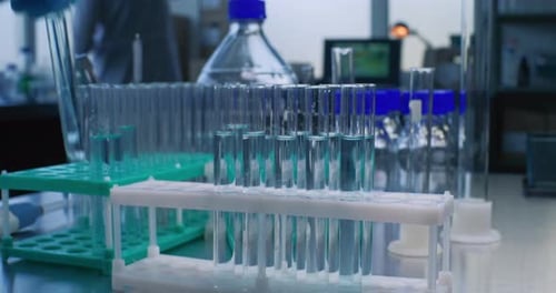 Close Up of Chemist Putting Test Tubes with Blue Liquid in Rack