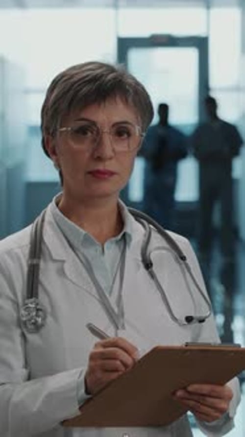 Portrait of Female Doctor with Clipboard during Workday in Hospital
