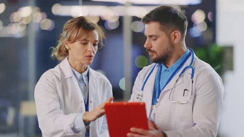 Caucasian Male and Female Doctors Collaborating in the Private Clinic Healthcare Couple Discussing