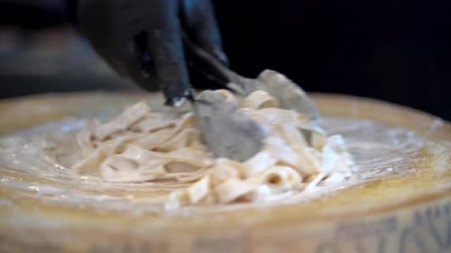 Pasta Being Mixed Inside a Cheese Wheel