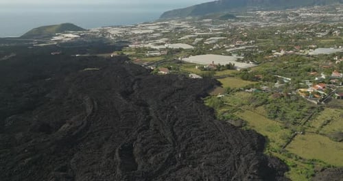 Solidified lava flow from volcanic eruption coming close to houses on La Palma