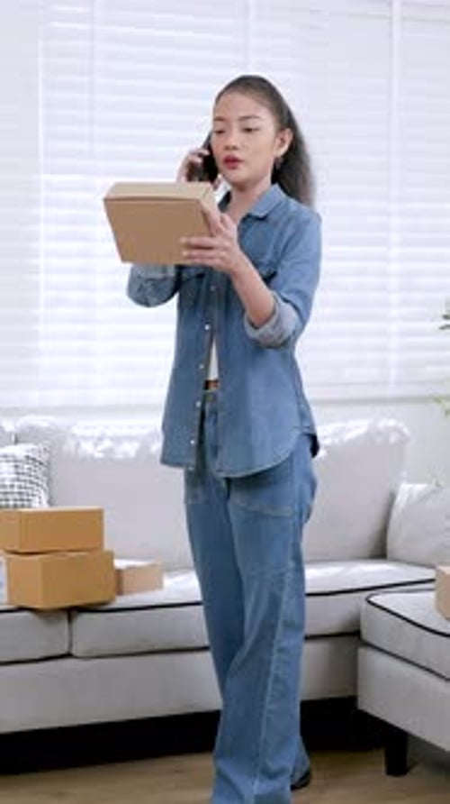 Young Woman Holds Box and Talks on Phone