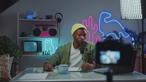 Video Blogger Talking in Mic in front of Digital Camera in Studio