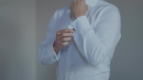 Man Fastens Cuff Links on Dress Shirt