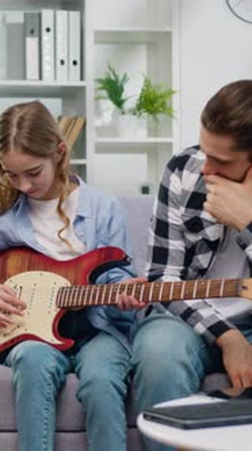 Girl learns guitar with help from her father