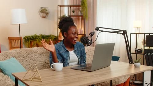 African American Blogger Woman Recording Vlog Podcast with Studio Microphone Smiling at Home Table