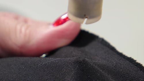 Sewer Attaching Metal Round Snaps to Clothes with Help of Manual Machine at Garment Factory