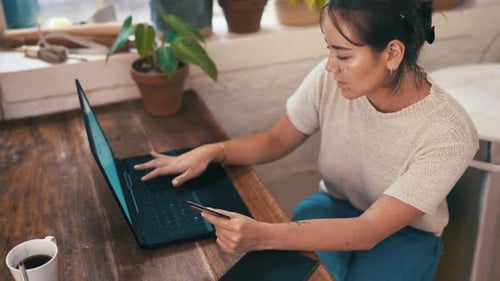 Woman, laptop or credit card for online shopping in workshop for inventory or product manufacturing