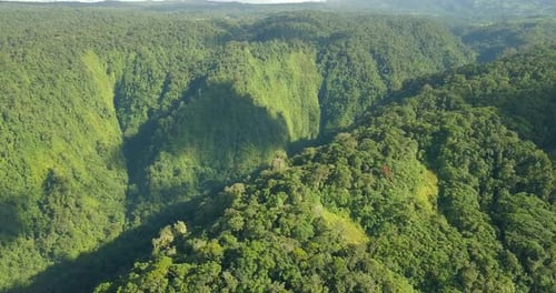 Slow smooth drone over lush green mountains dramatic lighting majestic shot