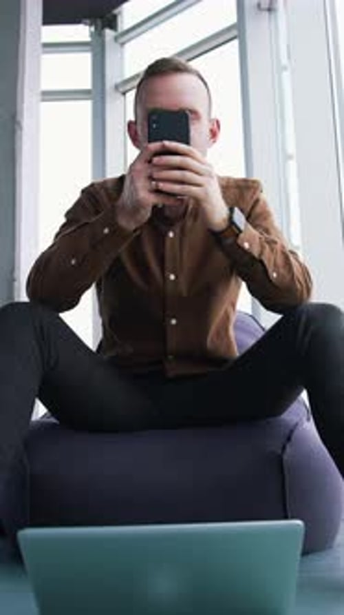 Young man with a phone in office.