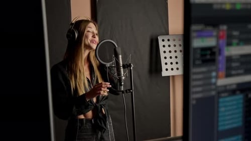 On the sound engineer's computer monitor sound tracks for mixing a new soundtrack that girl sings