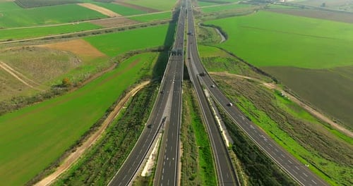 Day traffic on a countryside bridge surrounded by lush green landscape