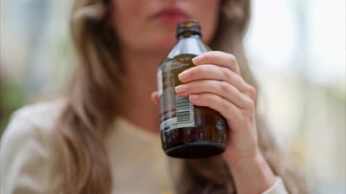 Gros plan d'une brune, d'une jeune femme buvant un thé kombucha à l'extérieur