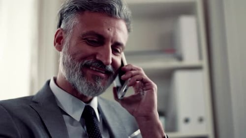 A Mature Businessman with Smartphone Making a Phone Call