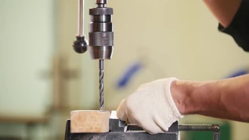 Industrial Drilling Machine Worker Makes Holes in Metal Plate