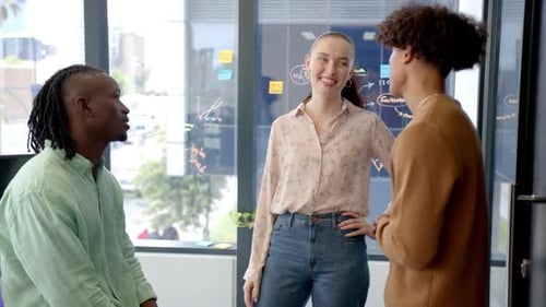Collaborating in office, three colleagues discussing project ideas and strategies