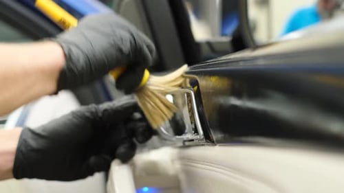 Car Detailer Cleaning Interior Door with Brush