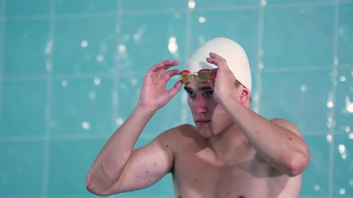 Young Man Adjusts Goggles Before Swimming Pool Dive