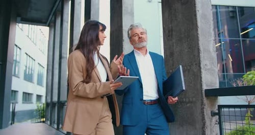 Closeup of Two Focused Business Man and Woman Professionals Outdoors Near a Modern Office Building