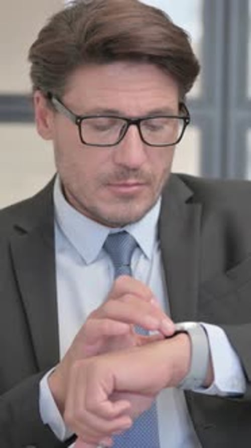 Man in Suit Interacts with Smart Watch