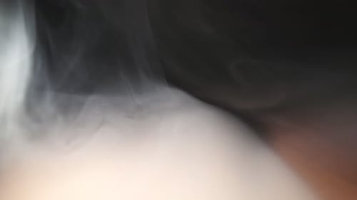 Pure Club of Milk Steam From an Electronic Cigarette or Vape Covering Surface of the Desk Close Up