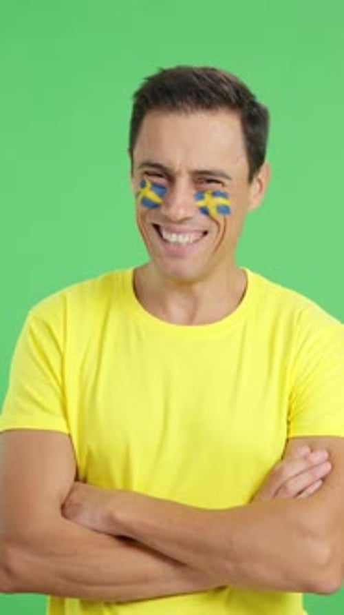 Man Standing with Swedish Flag Painted on Face Smiling