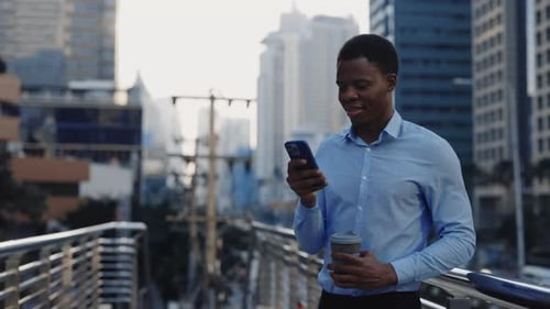 Confident Professional Lawyer Standing Outside Using Smartphone and Holding a Cup of Coffee