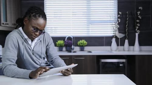 Man Using Tablet Device in Modern Kitchen Setting