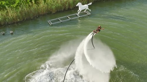 Aerial View Levitating Leisure A Girl's Flyboard Dance Over Water