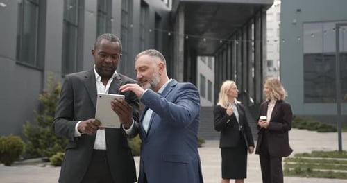 Business Colleagues Discussing on a Tablet Outdoors