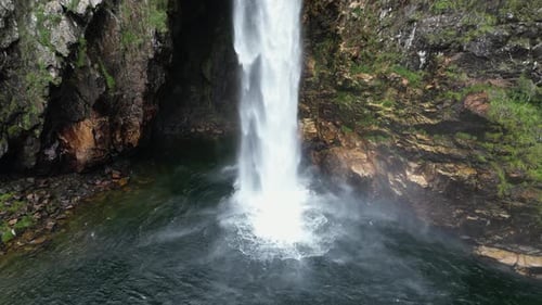 Shallow rock cavern behind freefalling Fundao waterfall in Brazil