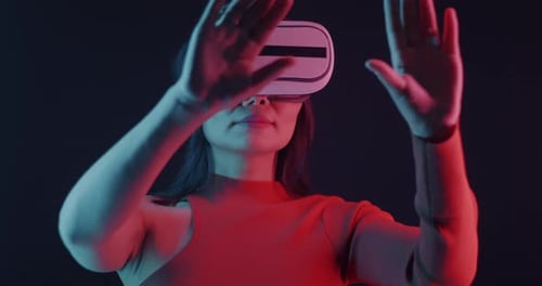 Woman Using Virtual Reality Headset with Hands Raised