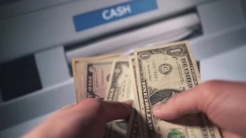 A Man Withdraws Cash From an ATM