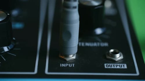 Precisely Arranged Synthesizer Input and Output Ports with Tidy Cabling and Subdued Studio Ambiance