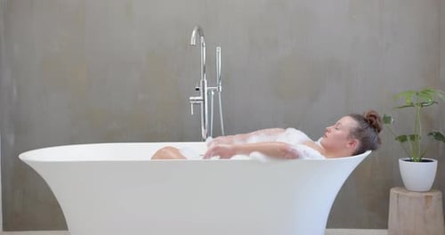 Relaxing in bathtub, woman enjoying spa day with bubbles and peaceful ambiance