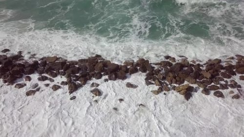 Massive Storm waves hitting and passing a wave breaker