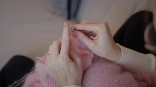 Woman Knitting a Pink Sweater at Home