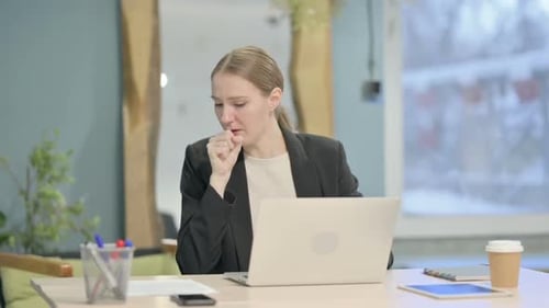 Woman Coughing While Working at Desk