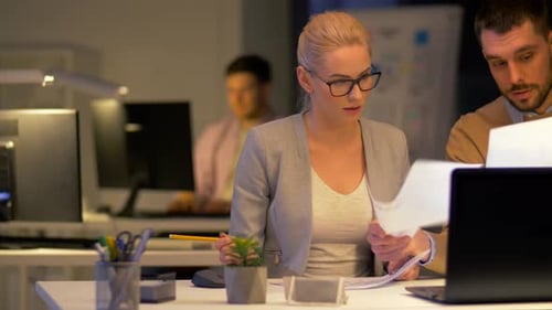 Equipe de negócios frustrada com o prazo de trabalho até tarde da noite em um escritório moderno