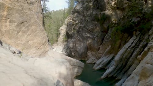 Images prises par Drone du ruisseau dans un canyon entouré d'une forêt de falaises rocheuses