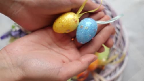 1. In der Mitte des festlich geschmückten Kranzes mit bunten Eiern befinden sich zwei Ostereier in Blau und