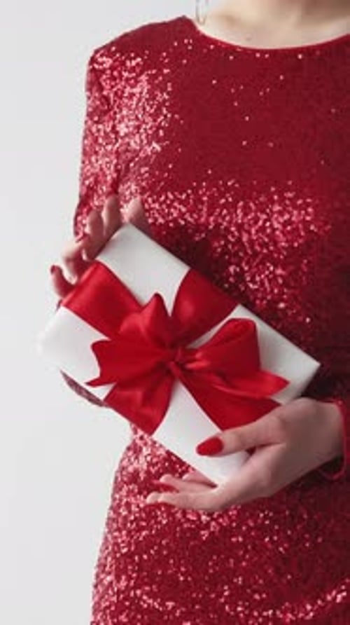 Woman Holding Gift Box with Red Ribbon in Studio