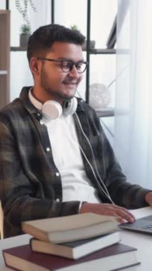 Young Adult Working on Laptop at Desk